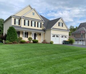 cream colored home with fresh cut lawn