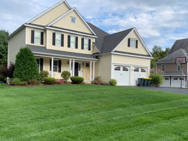 cream colored home with fresh cut lawn