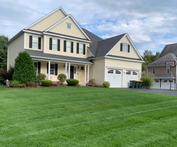 cream colored home with fresh cut lawn